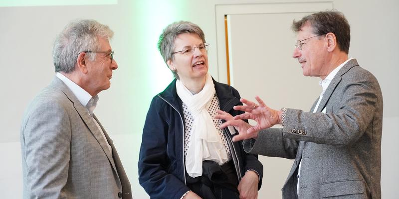 Drei Leute unterhalten sich angeregt und gestikulierend