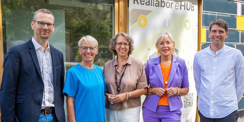 Five people standing on front of the eHUB smiling for a group photo