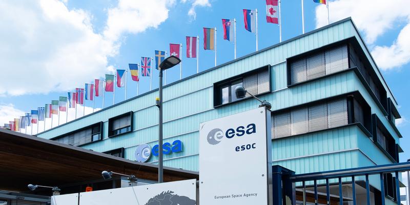 View of the facade of the European Space Operations Center (ESOC). Flags are flying on the roof.