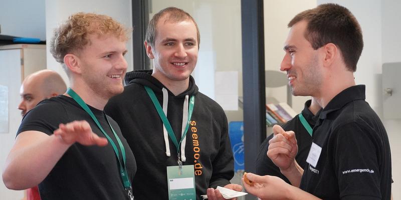 Three men are talking to each other.